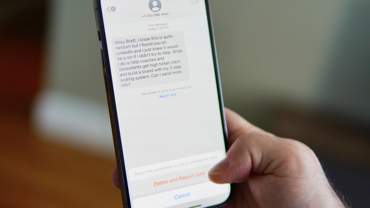 Hand holding a smartphone showing a text message thread, the kind of scam text you can report to 7726