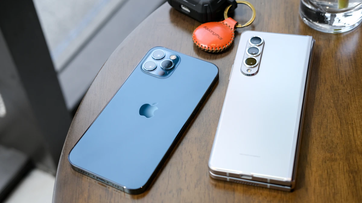 Two smartphones lying side by side on a wooden table, showing the choice between an iPhone and a Samsung Galaxy